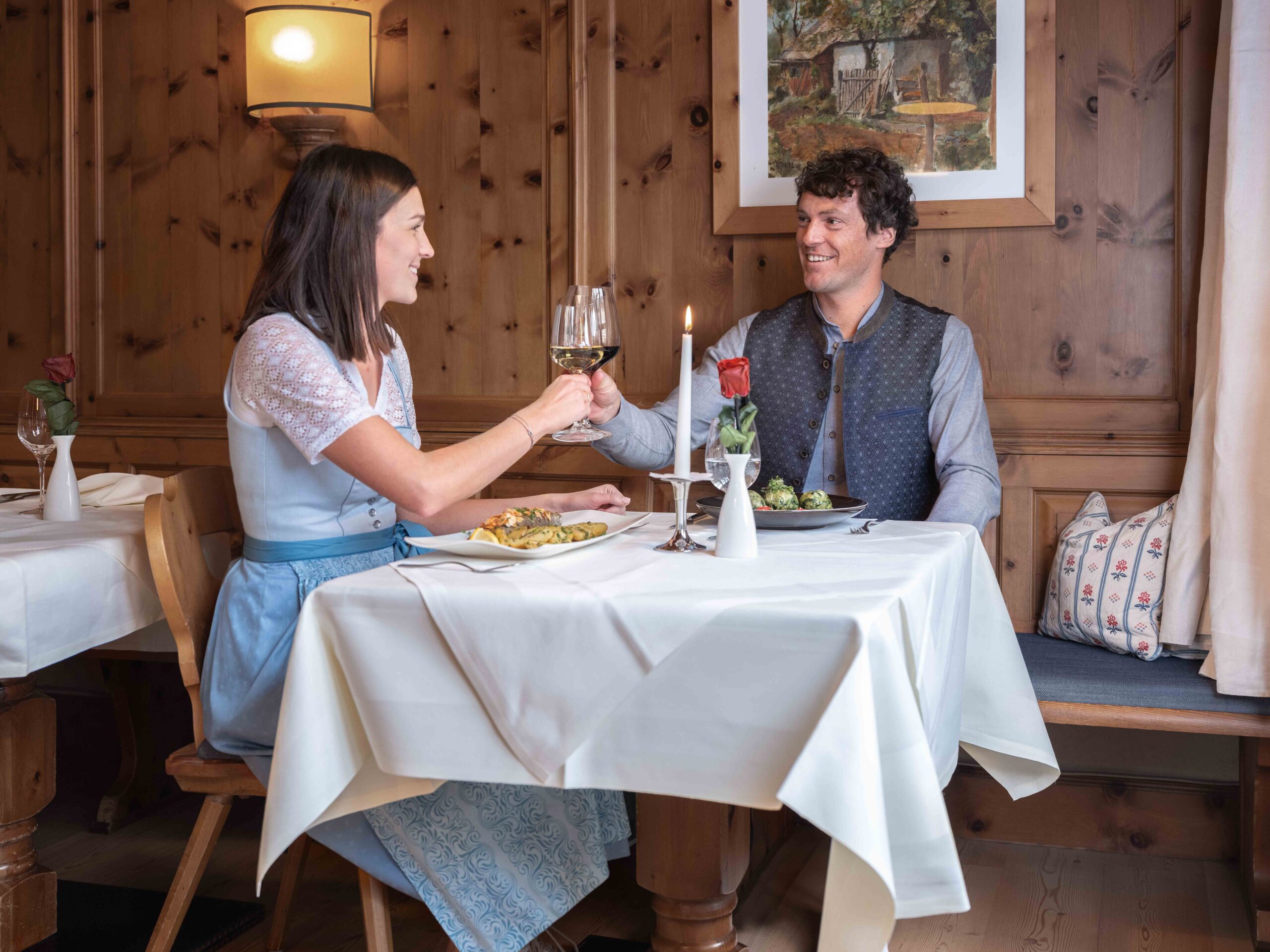 Ein Pärchen schenkt sich gerade einen Wein beim Mitagessen im Restaurant ein.