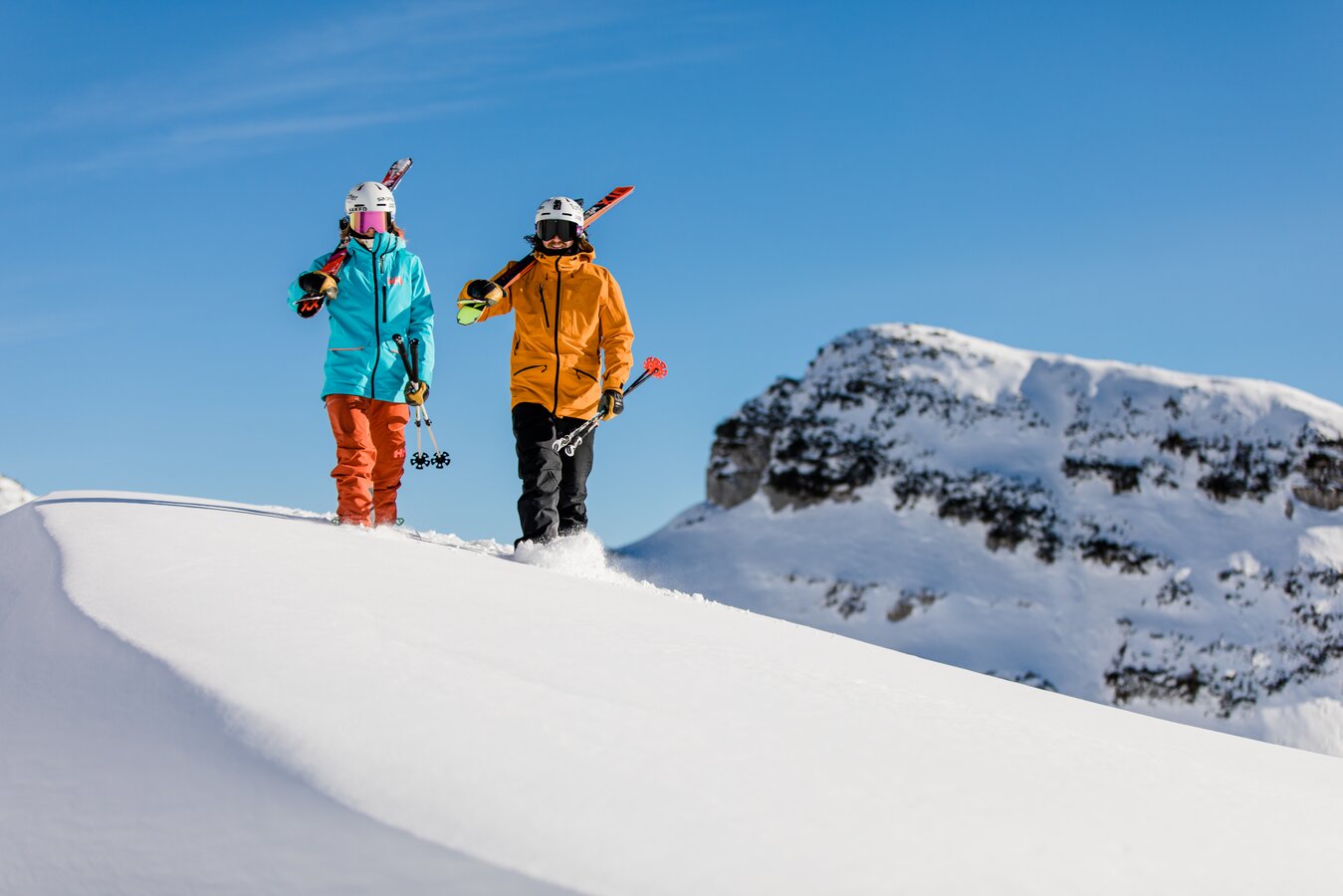 Zwei Skifahrer im Schnee auf einem Berg.