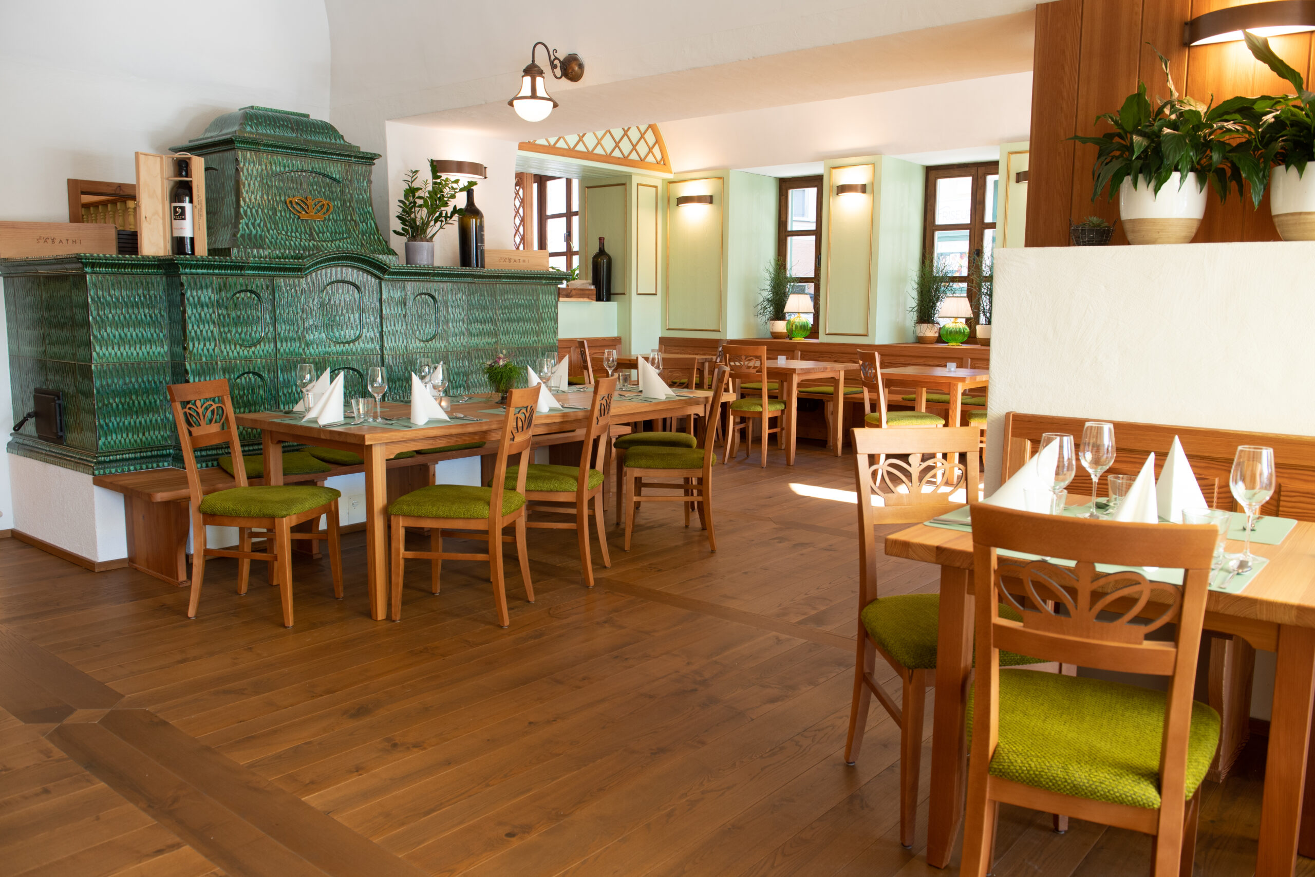 Gastraum im Wirtshaus s'JOHANN mit dem grünen Kachelofen auf der linken Seite.