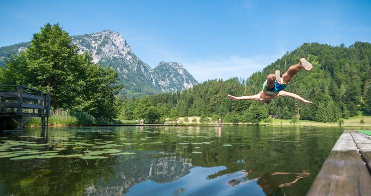 Ein Mann springt in einen Teich.