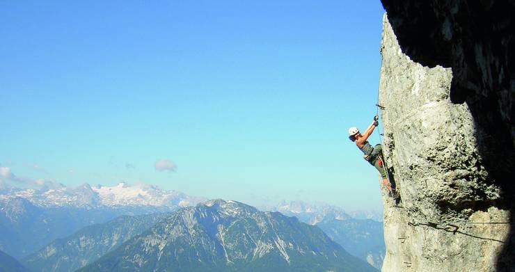 Kletterer im Felsen, Berge im Hintergrund.