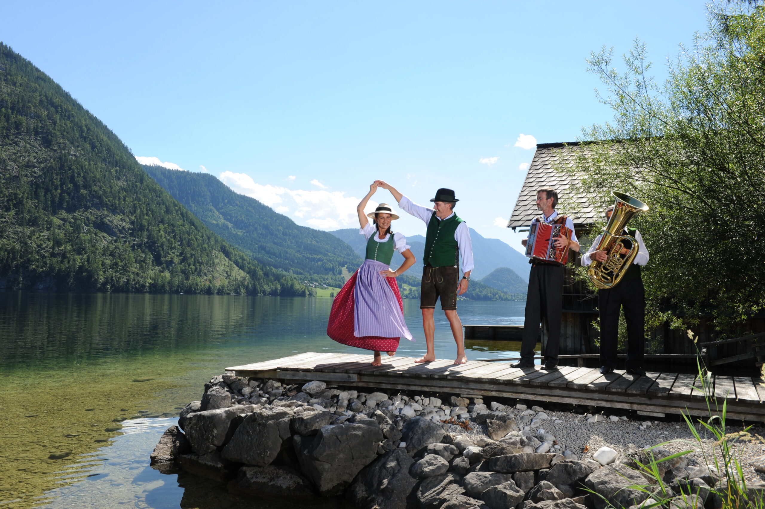 Trachtenpärchen tanzt mit Musikanten am Altausseer See.